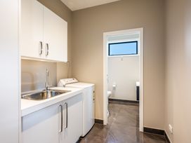 A laundry room with a washing machine and sink at Lake Hawea Holiday Home in Wanaka