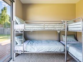 A bedroom with a bunk bed and sliding door at Lake Hawea Holiday Home in Wanaka