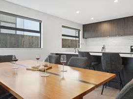 A dining room with a table and wine glasses at Bliss at Madras - Christchurch Holiday Home