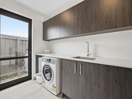 A laundry room with a washing machine and sink at Bliss at Madras - Christchurch Holiday Home