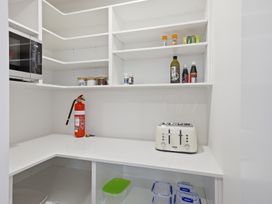 A pantry with a microwave and toaster at Bliss at Madras - Christchurch Holiday Home