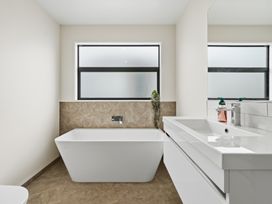 A bathroom with a bathtub and sink at Bliss at Madras - Christchurch Holiday Home