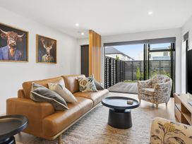A living room with a sofa and armchair in Bliss at Madras - Christchurch Holiday Home