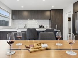 A kitchen with wine glasses and a cutting board with cheese and crackers at Bliss at Madras - Christchurch Holiday Home