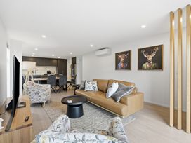 A living room with a sofa and armchair at Bliss at Madras - Christchurch Holiday Home
