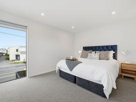 A bedroom with a bed and nightstand at Bliss at Madras - Christchurch Holiday Home