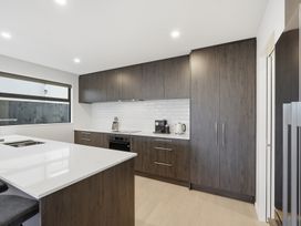 A kitchen with cabinets and appliances at Bliss at Madras - Christchurch Holiday Home