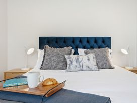 A bedroom with a bed and side table at Bliss at Madras - Christchurch Holiday Home
