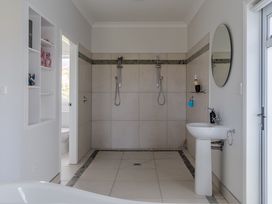 A bathroom with a shower and sink at Sunlit Shores - Papamoa Holiday Homes, Papamoa