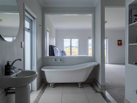 A bathroom with a bathtub and sink at Sunlit Shores - Papamoa Holiday Homes in Papamoa