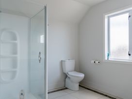 A bathroom with a shower and a toilet at Sunlit Shores - Papamoa Holiday Homes, Papamoa