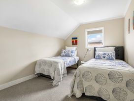 A bedroom with two beds and a window at Sunlit Shores - Papamoa Holiday Homes Papamoa