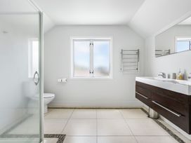 A bathroom with a shower and vanity at Sunlit Shores - Papamoa Holiday Homes in Papamoa