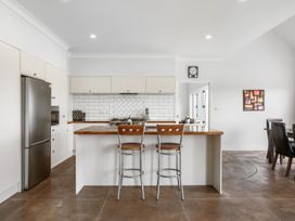 A kitchen with a refrigerator and cabinetry at Sunlit Shores - Papamoa Holiday Homes Papamoa