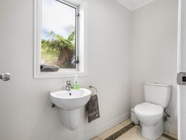 A bathroom with a toilet and sink at Sunlit Shores - Papamoa Holiday Homes, Papamoa