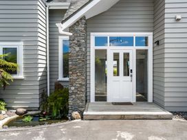 An outdoor entryway with a stone wall and front door at Sunlit Shores - Papamoa Holiday Homes Papamoa