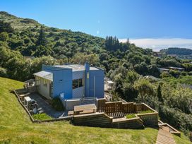 A house with a deck and grassy area at Lyttelton Holiday Home Lyttelton