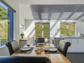 A kitchen with a dining table and wine glasses at Lyttelton Holiday Home in Lyttelton