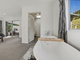 A bathroom with a bathtub and window at Lyttelton Holiday Home in Lyttelton