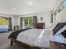 A bedroom with a bed and a bathtub at Lyttelton Holiday Home in Lyttelton