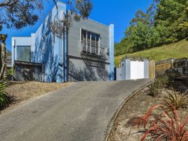 A house with a driveway and garage at Lyttelton Holiday Home, Lyttelton