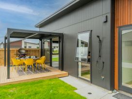 An outdoor patio with a table and chairs at Sun and Sea Sanctuary - Whitianga