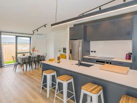 A kitchen with an island and dining area at Sun and Sea Sanctuary - Whitianga
