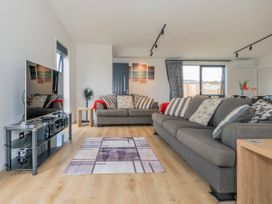 A living room with a television and two sofas at Sun and Sea Sanctuary - Whitianga