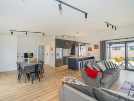 A living room and dining area with a sofa and table at Sun and Sea Sanctuary - Whitianga