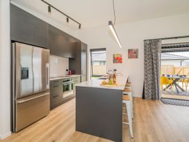 A kitchen with appliances and seating at Sun and Sea Sanctuary - Whitianga