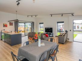 A living room with kitchen island and dining area at Sun and Sea Sanctuary - Whitianga