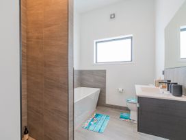 A bathroom with a bathtub, toilet, and sink at Sun and Sea Sanctuary - Whitianga