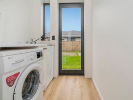 A laundry room with a washing machine and sink at Sun and Sea Sanctuary - Whitianga