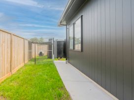 An outdoor area with grass and a fence at Sun and Sea Sanctuary - Whitianga