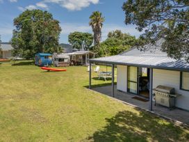 An outdoor space featuring a trailer, kayak, and picnic table at Whitianga Holiday Home in Whitianga