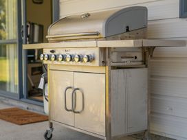 A grill with a cooking surface and cabinet at Whitianga Holiday Home in Whitianga