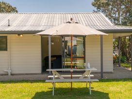 A table with an umbrella outside a building at Whitianga Holiday Home in Whitianga