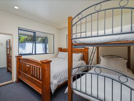 A bedroom with a double bed and a bunk bed at Whitianga Holiday Home in Whitianga