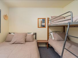 A bedroom with a bunk bed and a double bed at Whitianga Holiday Home in Whitianga