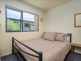 A bedroom with a bed and window at Whitianga Holiday Home in Whitianga