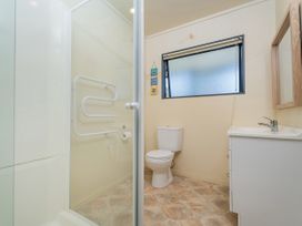 A bathroom with a shower, toilet, and sink at Whitianga Holiday Home in Whitianga
