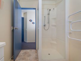 A shower with door in a bathroom at Whitianga Holiday Home in Whitianga