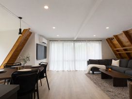 A living room with a sofa, table, and television at Peaks and Pines Chalet - Ohakune