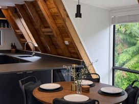 A dining room with a round table and plates at Peaks and Pines Chalet - Ohakune