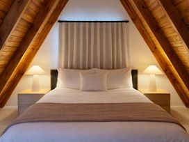 A bedroom with a bed and lamps at Peaks and Pines Chalet - Ohakune
