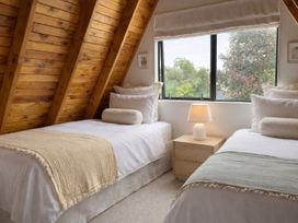 A bedroom with two single beds and a lamp at Peaks and Pines Chalet - Ohakune