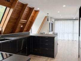 A kitchen with cabinets and a sink at Peaks and Pines Chalet - Ohakune