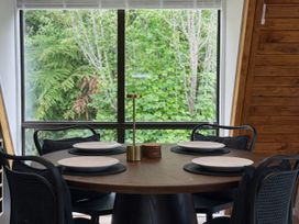 A dining room with a round table and chairs at Peaks and Pines Chalet - Ohakune
