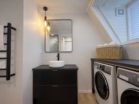 A laundry room with a washing machine and sink at Peaks and Pines Chalet - Ohakune