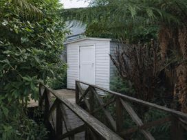 A garden shed with a wooden path surrounded by plants at Peaks and Pines Chalet - Ohakune